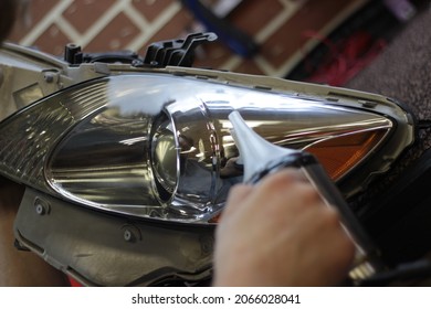 Car Headlight During Repair And Cleaning. Perfectly Smooth Headlight Glass. The Mechanic Restores The Headlight Of The Car With The Help Of A Chemical Kettle. Restoration Of Automotive Optics.