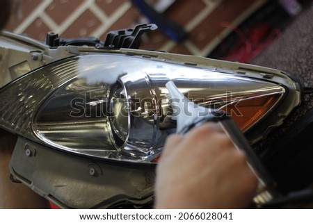 Car headlight during repair and cleaning. Perfectly smooth headlight glass. The mechanic restores the headlight of the car with the help of a chemical kettle. Restoration of automotive optics.