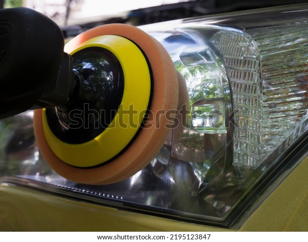 Car headlight polishing. Cleaning headlights with
a polishing machine