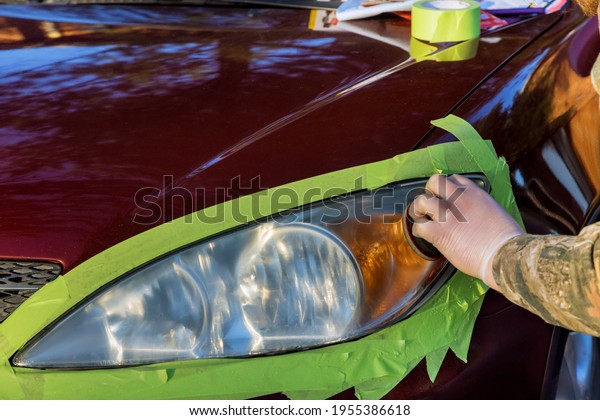 Car headlights cleaning with polishing machine at\
car service
