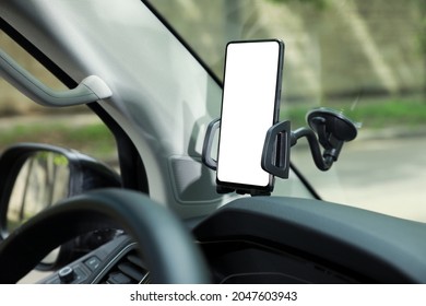 Car Holder With Modern Mobile Phone On Windshield Of Automobile. Mockup For Design