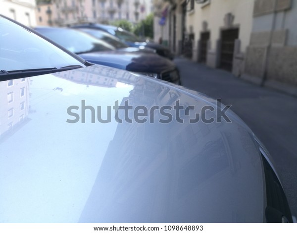 Car Hood Parked Cars in the Street. Parking\
Problems in Milan Italy