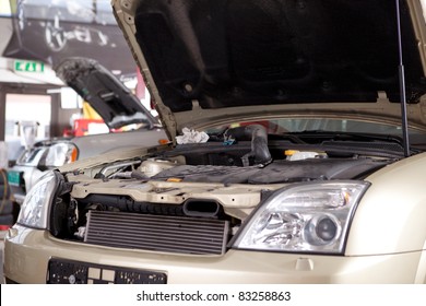 A Car With A Hood Up In A Professional Auto Repair Shop