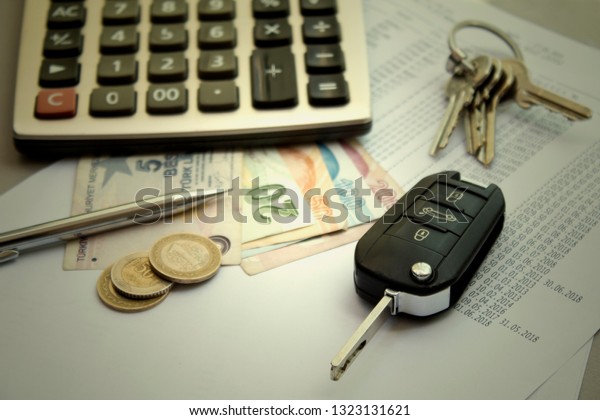 \
Car and house key, calculator with money on the\
table