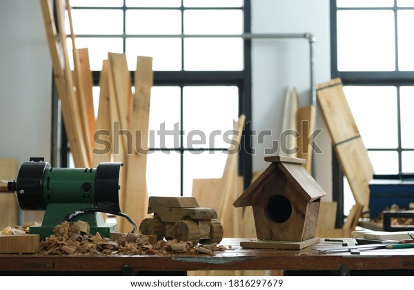 Car and\
house made of wood with craft tools on workbench.Table for making\
handmade wood work at carpenter\'s\
home.