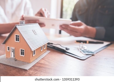 Car and House model with agent and customer discussing for contract to buy, get insurance or loan real estate or property background. - Shutterstock ID 1359311393