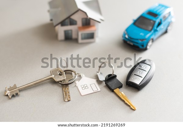 car and house model for sale with\
money, key on background, house for sale concept,\
closeup.