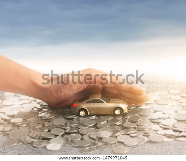 Car and\
house model with stack of a coins in  a\
hand
