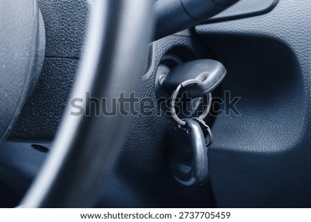 Car ignition with key inserted in steering column. Vehicle interior detail closeup. Starting engine concept. Automotive security and transportation theme. Driver perspective inside cabin.