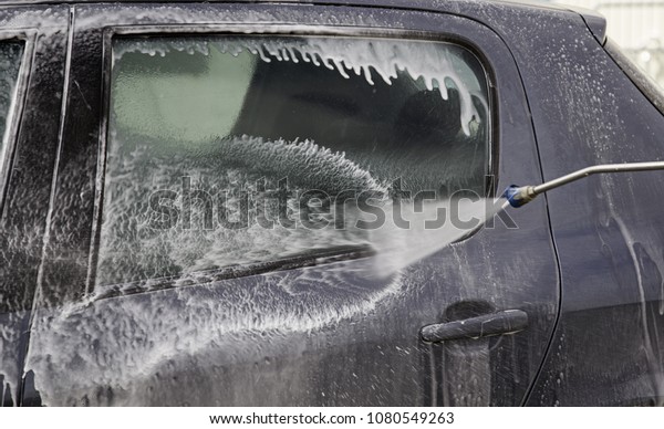 Car in industrial car wash, hygiene and cleaning\
of vehicles