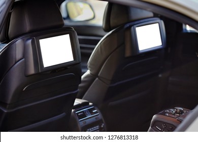 Car inside headrest screen mock up. Interior of prestige luxury modern car. Two white displays for back seats passenger with media control panel copy space and place for text.