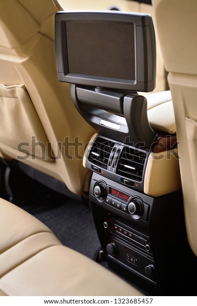 Car inside. Interior\
in cream colors leather of prestige luxury modern car. Swivel\
display for back seats passenger with media control panel vertical\
copy space mock up.