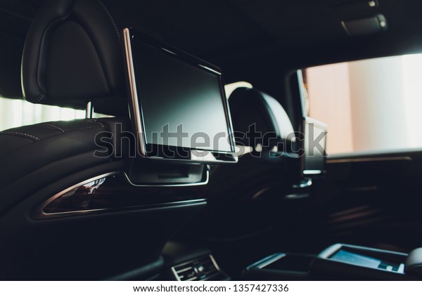 Car inside. Interior of prestige luxury modern car.\
Three TV displays for passenger with media control panel copy space\
and mock up.