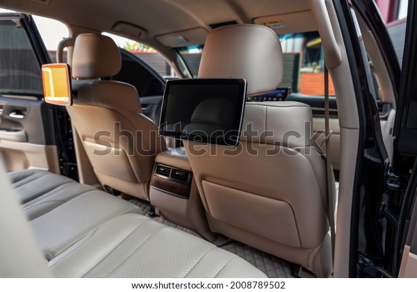 Car inside.\
Multimedia screens or TV displays for rear passenger seats. Luxury\
car interior with leather\
seats