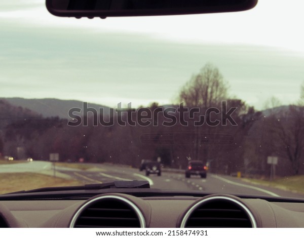 A car inside view of Blue Bridge mountain road\
surrounded by trees