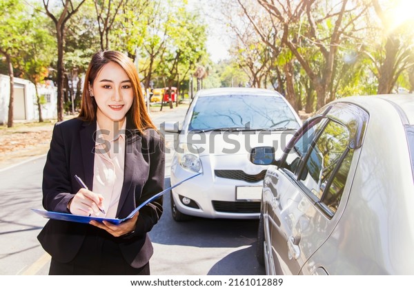 Car insurance business portrait beautiful\
female representative customer service to inspect the area\
responsible for car insurance during an accident Write down the\
information to the\
clipboard.