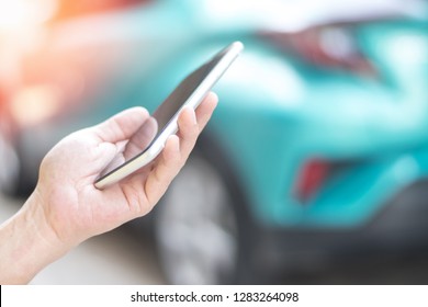 Car insurance claim technology and business concept. Hand using smartphone application or make a call  to inform insurance company in accident scene with green automobile background.  - Shutterstock ID 1283264098