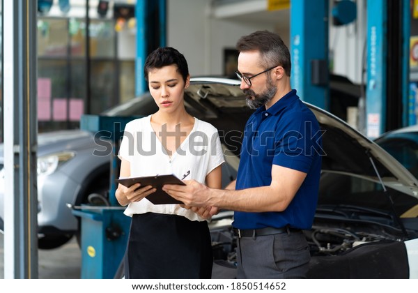 Car\
insurance concept. Insurance Agent examine Damaged Car with woman\
customer write information on Report Claim\
Form.
