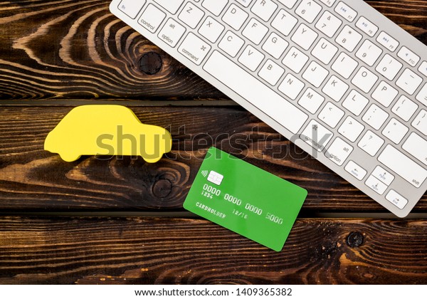 Car insurance concept with\
car, bank card and keyboard on wooden background top view\
mockup