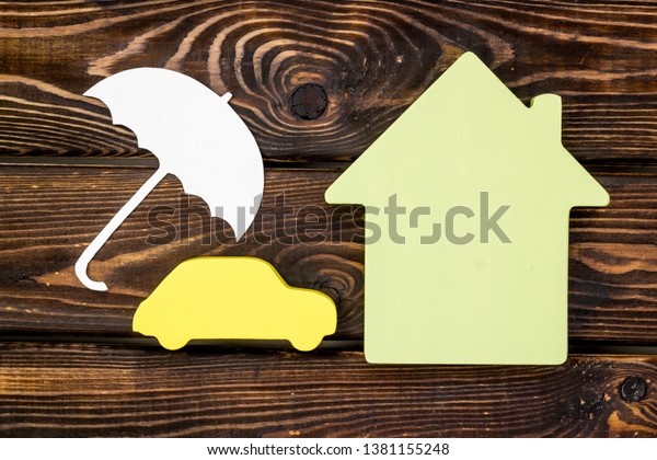 Car insurance concept with\
car, house and umbrella toys on wooden background top view\
mockup