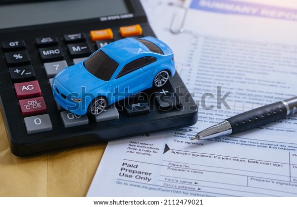 Car insurance concept.Signing insurance\
document papers with\
calculator.