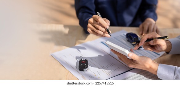 Car Insurance document or lease concept the car broker assisting his customer and explaining the detail of the car contact. Car key Buying or selling signing .	