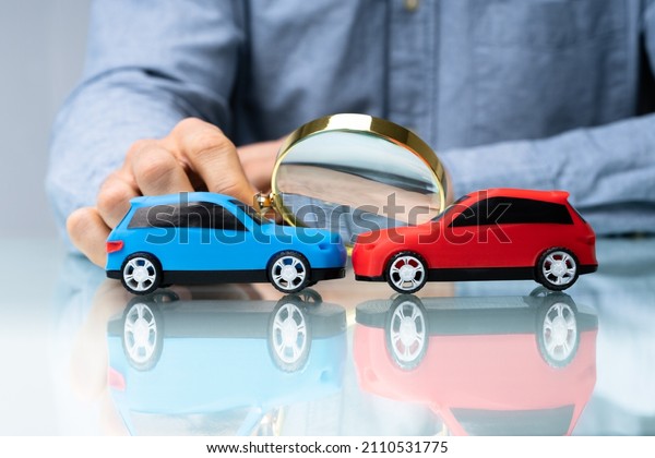Car Insurance Expert Investigating Vehicle Accident\
Using Magnifying Glass