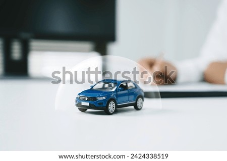Car insurance, vehicle protection concept. protect blue toy car under a glass dome in concept car care, insurance, and repair coverage covered automobile for financial security.