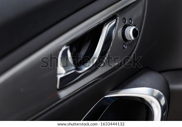 Car interior. Car door interior trim. Soft\
focus. Modern car illuminated dashboard. Luxurious instrument\
cluster. Close up shot of automobile instrument panel. Modern car\
interior dashboard