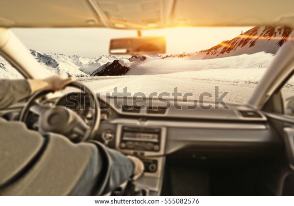 car interior with driver and winter road with snow and\
frost 