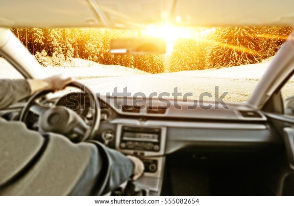 car interior with driver and winter road with snow and\
frost 