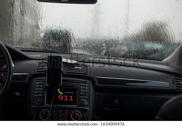 Car interior with emergency call on a radio\
display, concept of travel in\
storm
