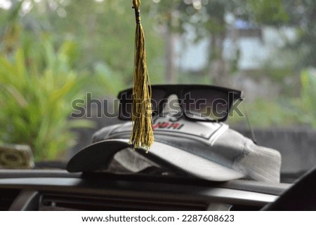 Car interior with hanging amulets charm on rear view mirror, and cap with mirror on the top