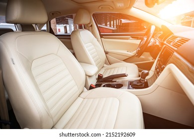 Car interior luxury. Beige comfortable seats, steering wheel, dashboard, climate control, speedometer, display, wood decoration light