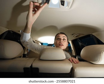 Car interior, woman in back seat a woman sits in the back seat of a car, her hand resting on the armrest of the front seat, suggesting a relaxed or thoughtful moment during the journey - Powered by Shutterstock