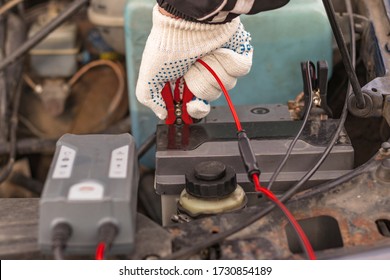 Car With Internal Combustion Engine. The Hood Is Open And The Battery Is Being Serviced.