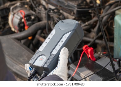 Car With Internal Combustion Engine. The Hood Is Open And The Battery Is Being Serviced.