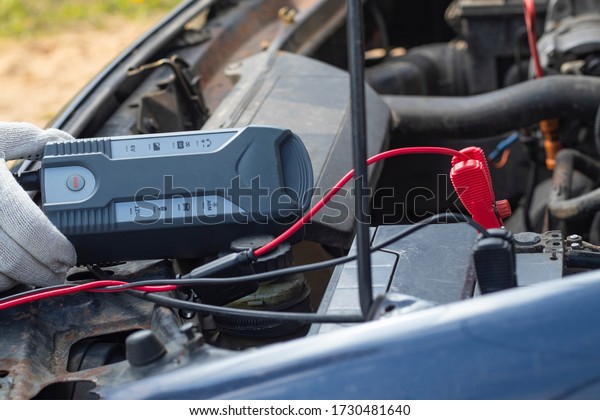 car with internal combustion engine.\
The hood is open and the battery is being\
serviced.