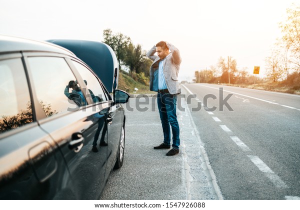 Car issue breakdown or engine\
failure. Elegant middle age man waiting for towing service for help\
car accident on the road. Roadside assistance\
concept.