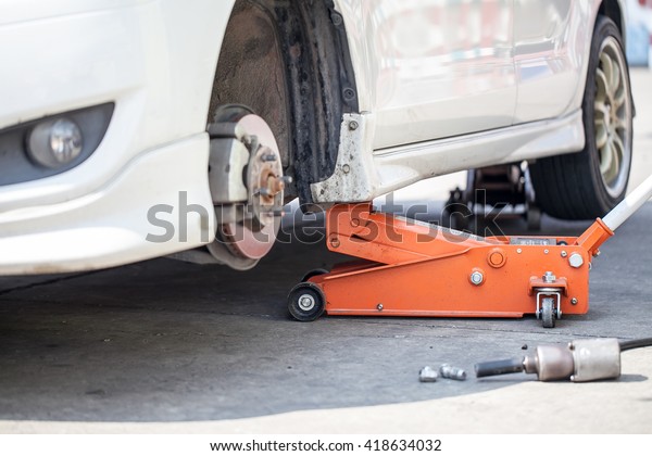 Car jack to lift car,\
changing car tire