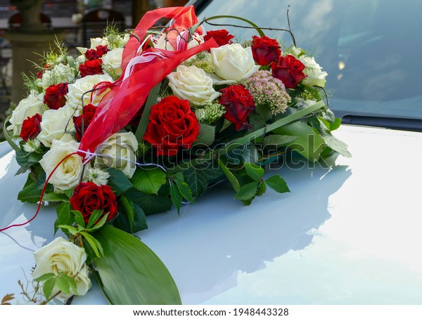 Car jewelry with red and white roses on a bonnet\
for the wedding. Copy space