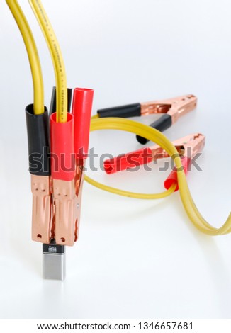 Car jumper cables connected to a 9 volt battery