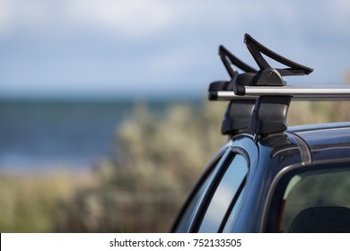 Car with kayak holders on roof-racks with the ocean in the background