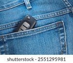 The car key in back pocket of trousers of a jeans fabric as background