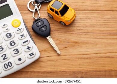 Car key with calculator on wood table background