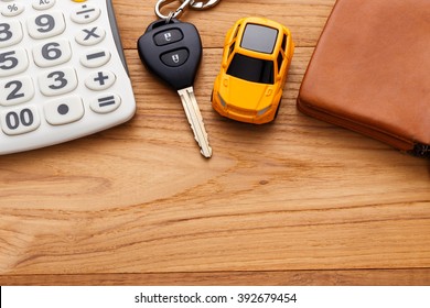 Car key with calculator and pocket money on wood table background