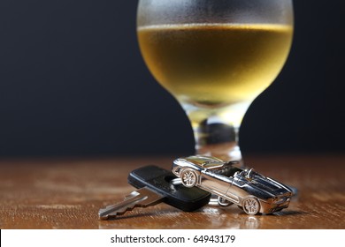 Car Key With Car-shaped Pendant And A Glass Of Beer. Drinking And Driving Concept