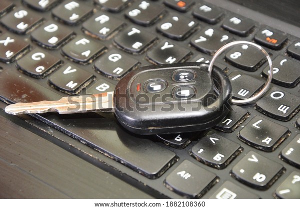 Car key\
and cell phone on laptop keyboard\
background