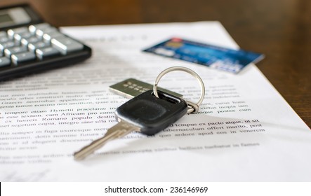 Car key, credit card on a signed sales contract, closeup