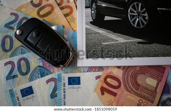 Car key and cut out new car catalog on euro\
money banknotes